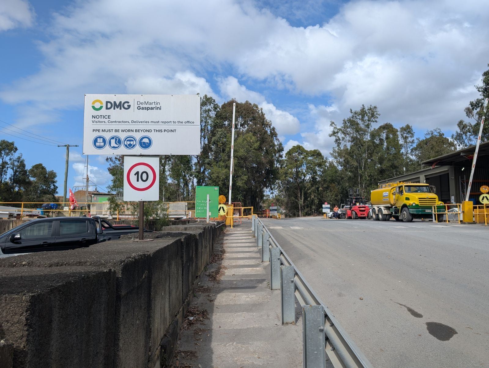 Yellow water tanker truck on a civil construction site entry